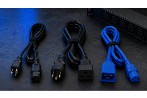 Multiple server power cord types — C13, C19, and locking IEC — laid out on a dark surface beside a rack PDU